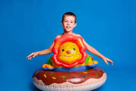 Téléchargez les photos : Garçon prêt à apprendre à nager dans la piscine sur fond de studio bleu clair - en image libre de droit