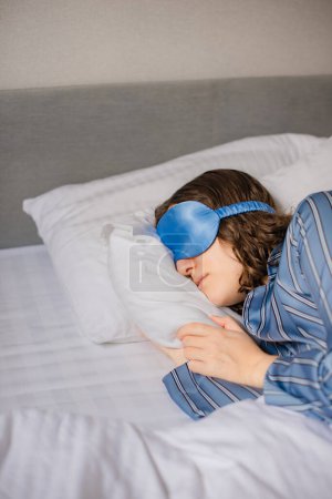 silk sleep eye mask for comfortable sleep. woman is asleep in bed in hotel