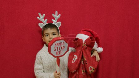 Photo for Cute kids brothers hugging and showing santa stop here sign. Christmas celebration and happy family. High quality photo - Royalty Free Image