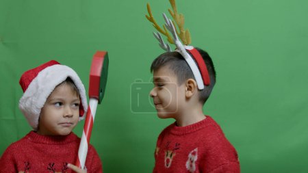 Photo for Naughty brothers inviting santa to come. Dancing and grabbing the sign. High quality photo - Royalty Free Image