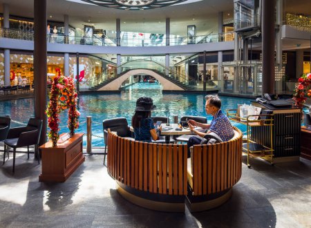 Téléchargez les photos : Singapour, 5 février 2024, vue d'un couple assis à une table près de l'Oculus Pluie aux Shoppes à Marina Bay Sands - en image libre de droit