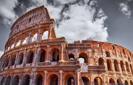 Colosseum (Coliseum or Colosseo) in Rome, Italy. Ancient ruins of Flavian Amphitheatre. Arena for gladiator fightings. World famous landmark and very popular touristic destination vacation trip