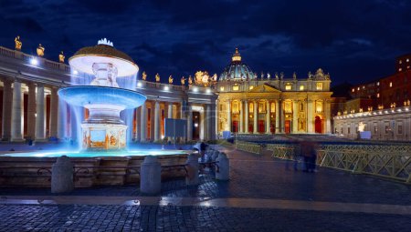 Photo for Vatican City (Holy See. Fountain in front of St. Peter's Basil cathedral on Saint Square. Nighttime, blue hour night sky street lamps. Rome, Italy. Famous travel destination and touristic landmark - Royalty Free Image