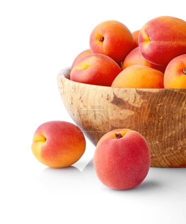 Téléchargez les photos : Abricots frais dans le bol en bois nature morte de fruits mûrs - en image libre de droit