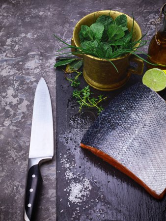 Téléchargez les photos : Poisson rouge saumon steak frais sur tableau noir en pierre avec couteau - en image libre de droit