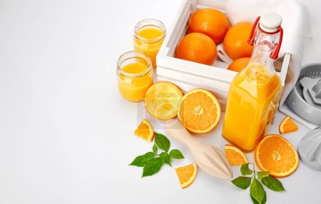 Téléchargez les photos : Jus d'orange frais aux fruits et feuilles vertes dans des pots en verre bo - en image libre de droit