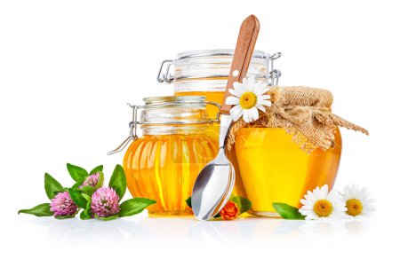 Téléchargez les photos : Miel frais sucré dans des bocaux en verre avec cuillère et fleurs isolés - en image libre de droit