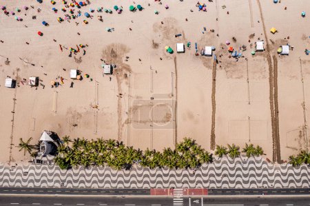 Téléchargez les photos : Vue aérienne du haut vers le bas de la célèbre plage de Copacabana avec des personnes se relaxant sur la plage et des palmiers - en image libre de droit