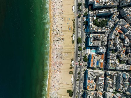Téléchargez les photos : Angle élevé de Copacabana Beach avec zone urbaine à côté de la rue près de la plage. Personnes se relaxant sur le sable, journée ensoleillée, Rio de Janeiro, Brésil - en image libre de droit