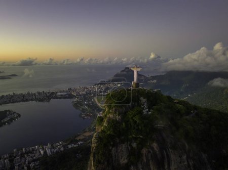Téléchargez les photos : Au sommet de la colline du Corcovado avant le lever du soleil. Vue aérienne de la ville avec Botafogo Bay et Sugarloaf Mountain à Rio de Janeiro, Brésil. Ciel chaud - en image libre de droit