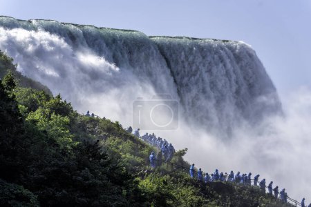 Foto de La gente observando una enorme masa de agua proveniente de las Cataratas del Niágara, la niebla del agua se eleva sobre la cascada - Imagen libre de derechos