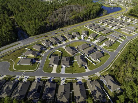 Téléchargez les photos : Vue aérienne du développement résidentiel américain typique avec route asphaltée au bord du bois - en image libre de droit