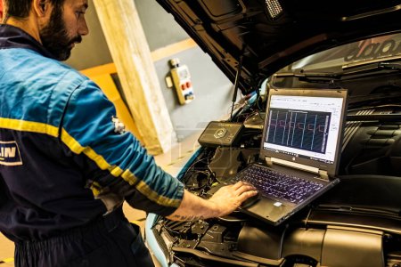 Foto de Milán, Italia 13 de noviembre de 2022: Mecánico realiza la sintonía de chips en un coche sintonizado en un taller de garaje - Imagen libre de derechos