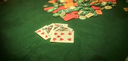 Téléchargez les photos : A chaotic scene of a poker game with chips scattered haphazardly across the table. Blurry background of a poker player sitting at the table. - en image libre de droit