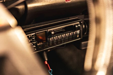 Close-up of a classic car radio with push buttons and tuning dial.