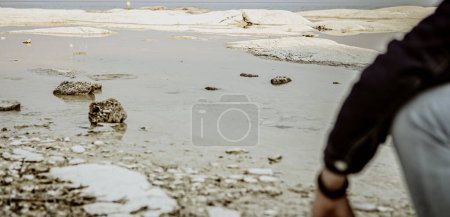 Photo for Skipping Stone: Boy Skips Stone Across Water - Royalty Free Image