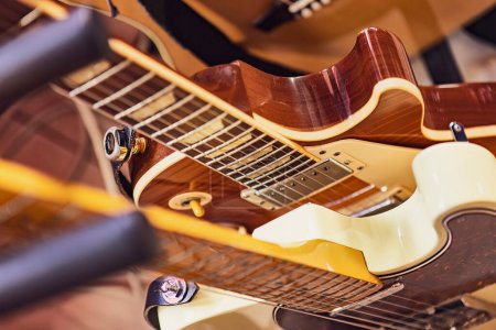 Photo for A close-up photo of multiple electric guitars in a row, showing their details and colors. Perfect for music themes and designs. - Royalty Free Image