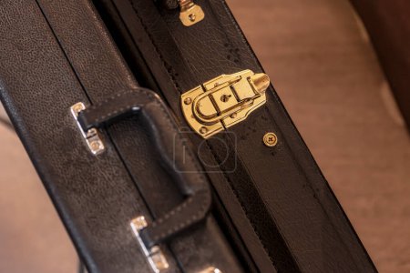 Photo for Close-up shot of a guitar case being securely closed, ready for travel or storage. - Royalty Free Image