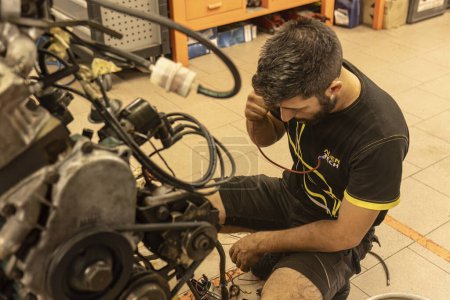Foto de Milán, Italia 23 de octubre de 2023: Mecánico artesano restaura meticulosamente un viejo motor vintage a su antigua gloria. - Imagen libre de derechos