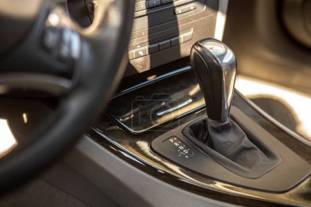 Close-up of a modern car's automatic gearshift lever, showcasing sleek vehicle design.