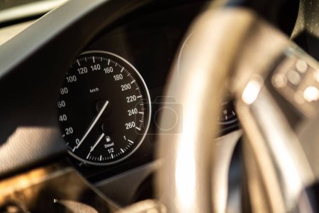 Un primer plano de un velocímetro dentro de un coche, que muestra el dial de velocidad alcanzando números altos a medida que el vehículo acelera.