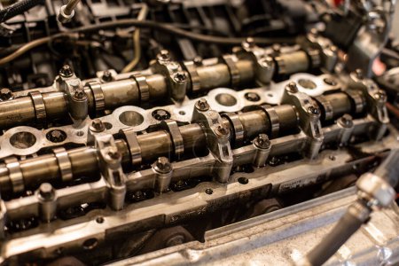 Nahaufnahme des demontierten Motors eines Autos mit Nockenwellen-Detail während der Reparatur in der Werkstatt.
