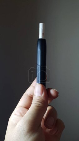 Téléchargez les photos : IQOS est une cigarette électronique fabriquée par Philip Morris International destinée aux fumeurs afin de réduire leur exposition aux produits chimiques nocifs de la cigarette conservatrice, Jakarta 27 juillet 2023 - en image libre de droit