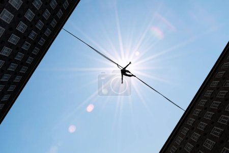Téléchargez les photos : Silhouette of tightrope walker balancing on the rope concept of risk taking - en image libre de droit