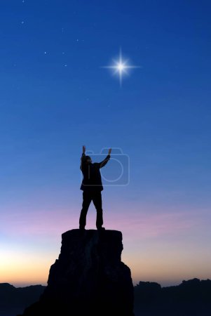 Photo for Man praying and worshiping with both hands raised towards the first star, backgrounds for Christmas vertical image - Royalty Free Image