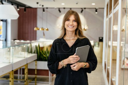 Photo for Positive friendly mature middle age a beautiful female business owner in a jewelry shop, portrait. - Royalty Free Image