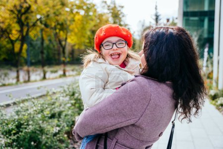 Photo for Cute little girl in a red beret with special needs enjoy having fun spending time with mother outdoor in aututm time. Happy family moments concept. - Royalty Free Image