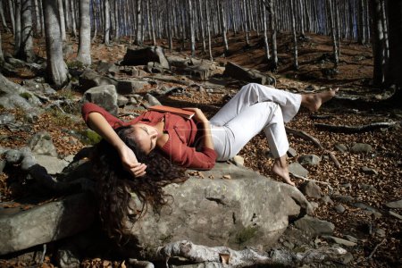 Téléchargez les photos : Documentation photographique d'une belle fille désireuse de lire dans un bois à l'automne - en image libre de droit