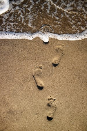 Téléchargez les photos : Empreintes photographiques de personnes sur sable gris - en image libre de droit