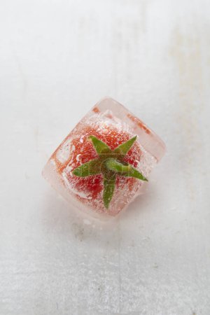 Photo for Photographic documentation of some small tomatoes inside an ice cube - Royalty Free Image