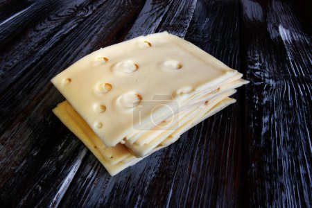 Photo for Cheese slices on a wooden table - Royalty Free Image