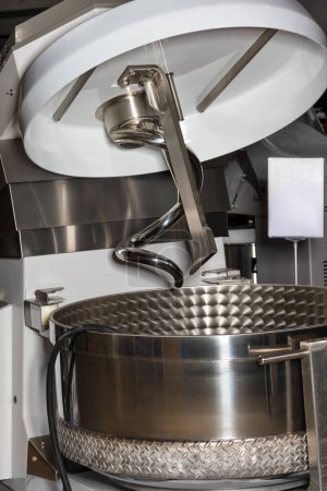 Foto de Un fragmento de un tazón mezclador espiral de acero inoxidable para la industria alimentaria para preparar una gran cantidad de masa. - Imagen libre de derechos