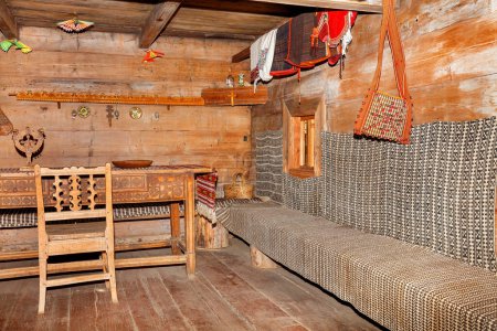 Foto de Muebles antiguos tallados en la sala de estar de una cabaña rural en el estilo tradicional ucraniano con toallas bordadas, loza y utensilios de madera. 10.09.2021. Kiev. Ucrania - Imagen libre de derechos