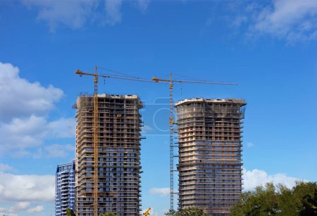 Photo for Multi-storey high-rise residential buildings are built using a monolithic-frame method, tower cranes are fixed along the floors of the buildings. - Royalty Free Image