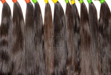 Foto de Paquetes naturales de cabello humano sano y liso en color chocolate en varios tonos para extensiones y hacer pelucas. - Imagen libre de derechos