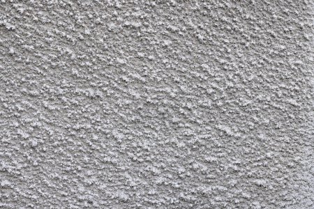 Gray, prickly, pimply texture of wall plaster with a uniform, uniform coating. Plaster for walls based on quartz sand and cement.