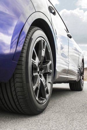 Photo for Car on sky background. Car wheels close up on a background of asphalt. Car tires. Car wheel close-up. for advertising - Royalty Free Image
