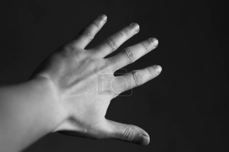 Téléchargez les photos : Main d'homme sur fond noir - en image libre de droit
