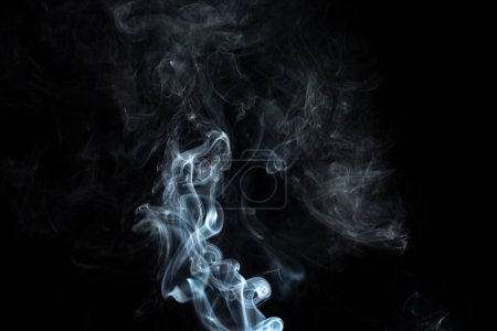 Räucherstäbchen mit weißem Rauch vor schwarzem Hintergrund