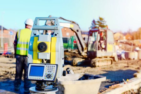 Close-up of surveyor optical equipment  tacheometer or theodolite on construction site with selective focus and blurred background
