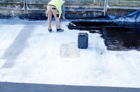 Waterproofing coating. Builder applying waterproofing bitumen mastic on concrete