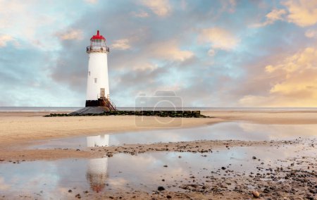 view of a lighthouse standing at the coast of Wales  the North Sea  at sinrise, United Kingdom