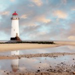 View of a lighthouse standing at the coast of Wales  the North Sea  at sinrise, United Kingdom