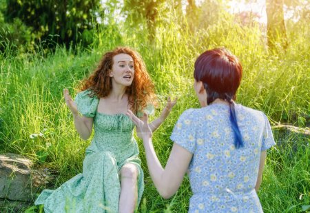 Photo for Two young women, couple, girlfriends swearing and argueing with each other in park. The concept of disagreements in the family, between friends, couple - Royalty Free Image