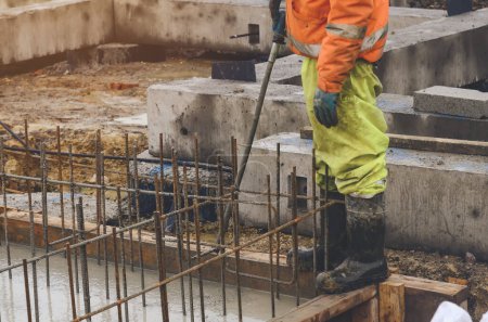 Betonarbeiten. Bauarbeiter ebnen nassen Beton. Betonarbeiten auf Baustelle