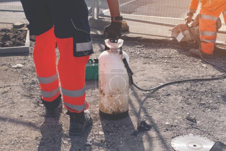 Téléchargez les photos : Travailleur de fond découpe l'asphalte avec scie à essence - en image libre de droit